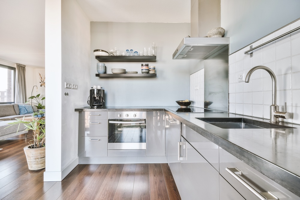 mała kuchnia w bloku z zabudową i srebrnymi urządzeniami  mała kuchnia w bloku z drewnianą podłogą i szarymi ścianami