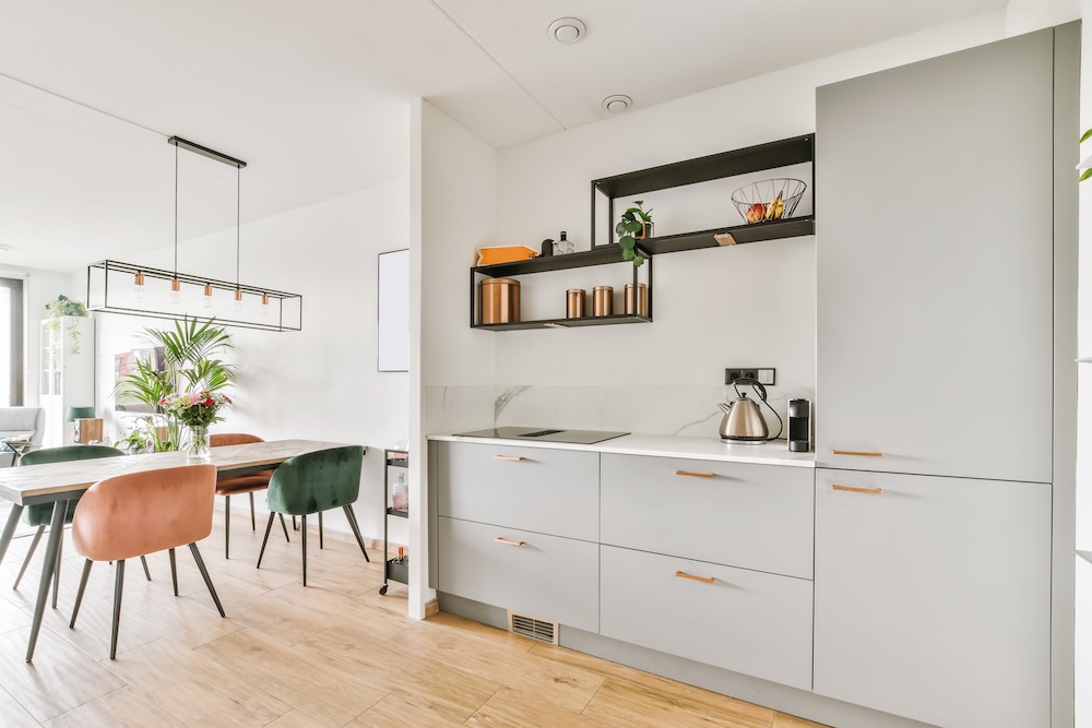 mała kuchnia w bloku z białymi ścianami i szarymi frontami  mała kuchnia w bloku z szarymi szafkami i złotymi uchwytami