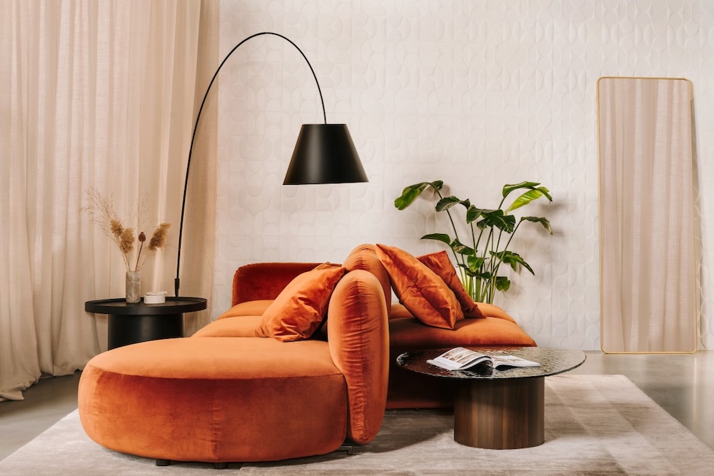 welurowa sofa w rudym odcieniu z wiszącą czarną lampą ruda welurowa sofa w pokoju z dwoma stolikami