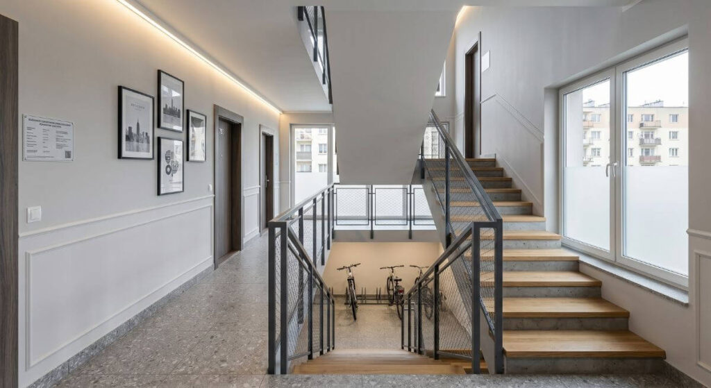 Klatka schodowa - inspiracje do bloku z szarymi ścianami i solidnymi stalowymi barierkami